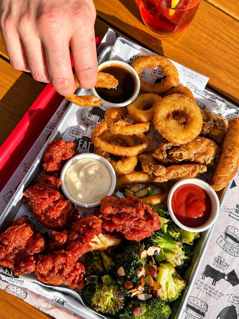 A sharing tray of onion rings, chicken and sides at Eat Burger