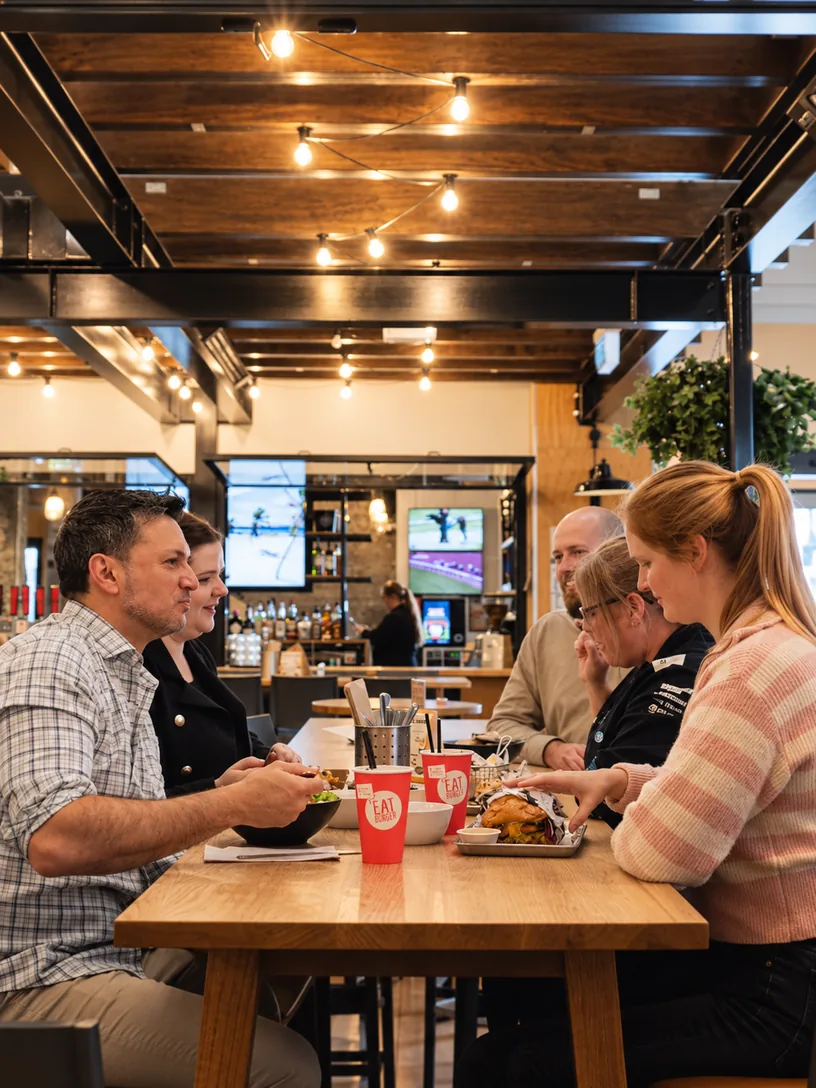 Friends sharing a meal inside Eat Burger